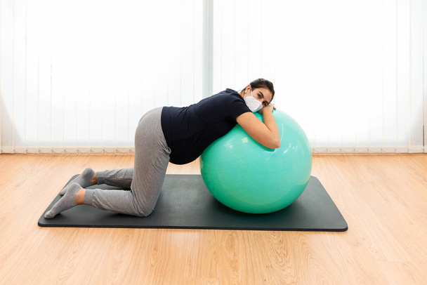 Ciężarna kobieta wykonuje ćwiczenia oddechowe i spoczywa na piłce fitness - Zdjęcie, obraz
