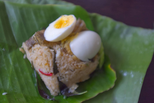 Çıtır Gourami balığı ve muz yaprağında haşlanmış yumurtalı pilav. - Fotoğraf, Görsel