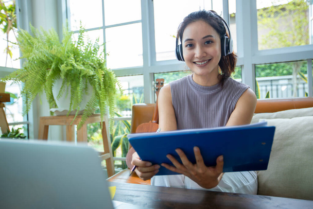 Asian businesswomen is using notebook computers and wear headphones for online meetings and working from home. - Photo, Image