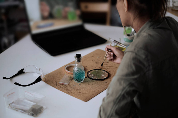 woman fixes glass plates. A picture of dried flowers. Master class on creating frame. be more creatively engaged. A Life of Happiness and Fulfillment - 写真・画像