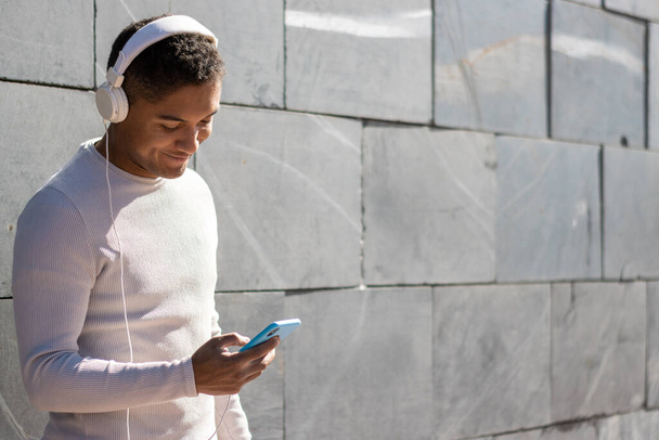 A man enjoying listening to music through headphones with his phone - Photo, Image