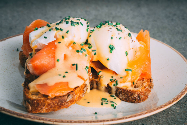 A closeup shot of a gourmet egg and salmon sandwich on a plate - 写真・画像