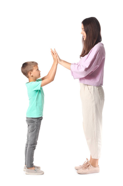Маленький хлопчик і його старша сестра дарують один одному п'ять на білому тлі
 - Фото, зображення