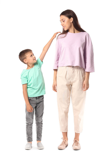 Kleine jongen met zijn oudere zus op witte achtergrond - Foto, afbeelding
