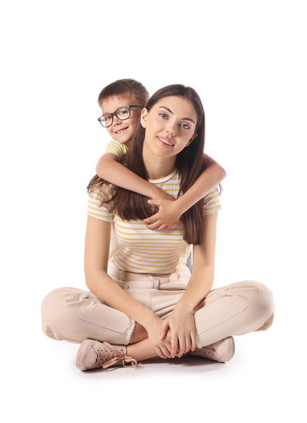 Little boy hugging his older sister on white background - Фото, изображение