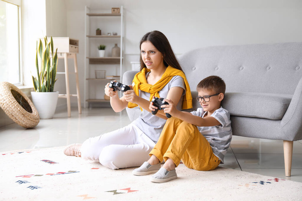 Маленький хлопчик зі своєю старшою сестрою грає у відеогру вдома
 - Фото, зображення