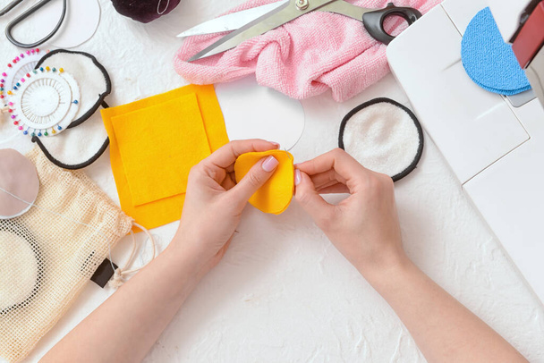 Woman with needle making reusable cotton pad on white background - Fotó, kép