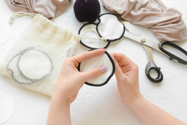 Woman stitching reusable cotton pad on white background - Photo, Image