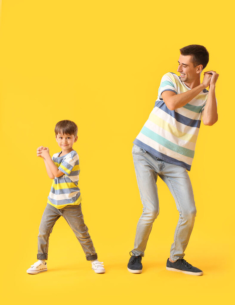 Dancing man and his little son on color background - Photo, Image
