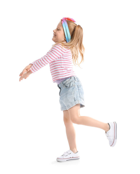 Nettes kleines Mädchen in gestreiftem Langarm, das auf weißem Hintergrund tanzt - Foto, Bild