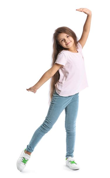 Roztomilé holčička v tričku tanec na bílém pozadí - Fotografie, Obrázek