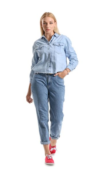Fashionable young woman in stylish jeans clothes on white background - 写真・画像