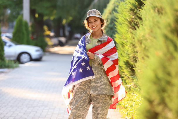 アメリカ国旗を屋外に持つアフリカ系アメリカ人女性兵士 - 写真・画像