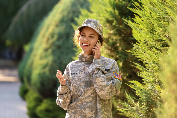 African-American female soldier talking by phone outdoors - Photo, Image