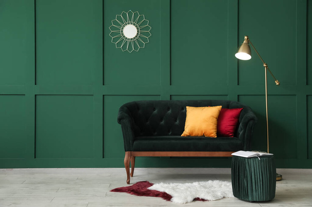 Современный интерьер со стильным диваном возле зеленой стены - Фото, изображение