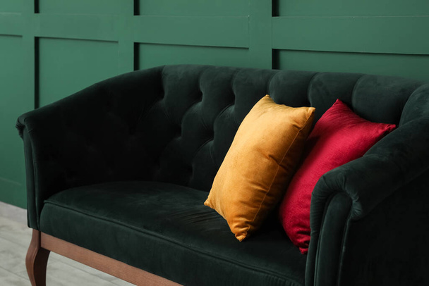 Современный интерьер со стильным диваном возле зеленой стены - Фото, изображение