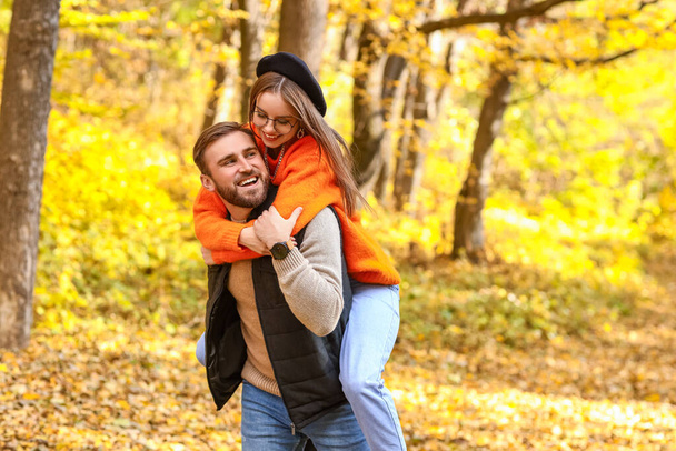 Młody mężczyzna i jego dziewczyna dobrze się bawią w jesiennym parku - Zdjęcie, obraz