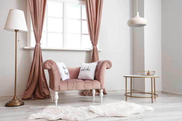 Interno di soggiorno luminoso con poltrona rosa, tavolo e lampade - Foto, immagini