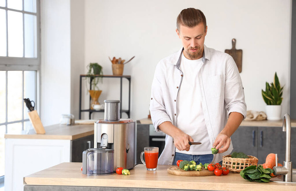 若い男は台所で健康な野菜ジュースを準備 - 写真・画像