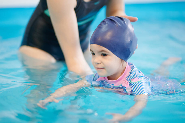 Gyerekkori témából tanulok úszni. Gyerek úszás kék medence víz - Fotó, kép