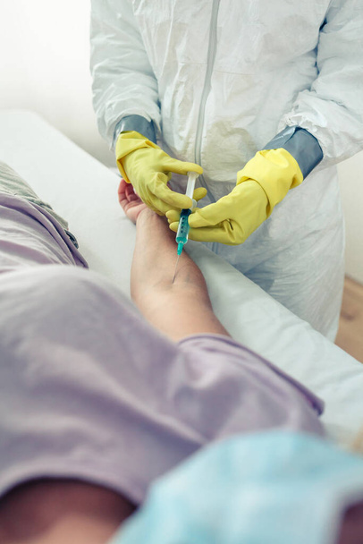 Unrecognizable female doctor injecting vaccine to patient - Foto, afbeelding