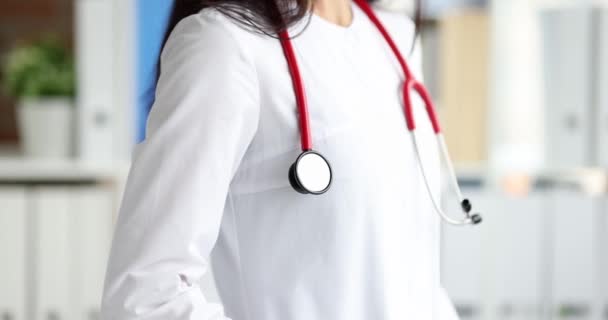 Γυναίκα γιατρός σε ιατρική στολή με κόκκινο στηθοσκόπιο closeup - Πλάνα, βίντεο