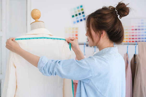 Fashion designer working in studio, cutting drawing, sewing dress - Photo, Image