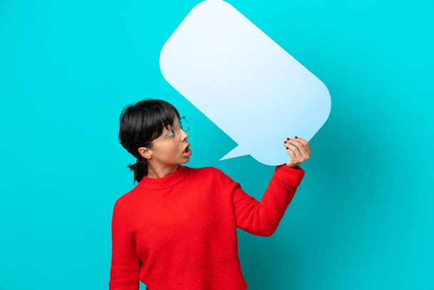 Young woman isolated on blue background holding an empty speech bubble - Photo, Image