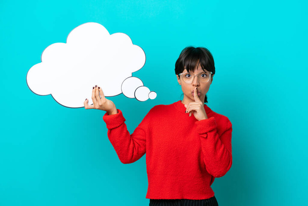 Young woman isolated on blue background holding a thinking speech bubble and doing silence gesture - Photo, Image