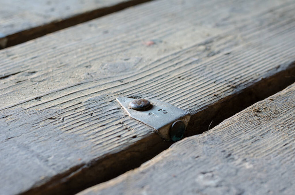 Nummer 13. Een oud bord met een aluminium plaatje. Metalen staaf aan de vloer genageld. Een close-up. Selectieve focus. - Foto, afbeelding
