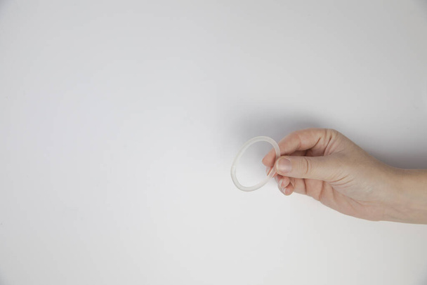 Prsten pro kontrolu porodnosti v ženské ruce izolované na bílém pozadí, vaginální kroužek pro antikoncepční použití zblízka kopírovací prostor - Fotografie, Obrázek