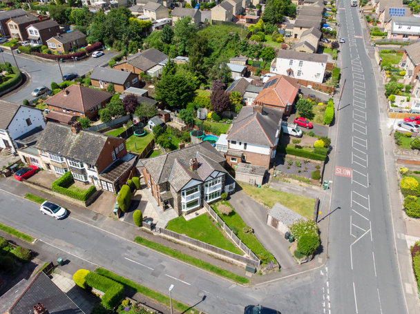 Zdjęcie lotnicze miasta Batley w Yorkshire UK, pokazujące typowe brytyjskie osiedla mieszkaniowe z drogami i ulicami, zrobione dronem w słoneczny dzień nad domami. - Zdjęcie, obraz