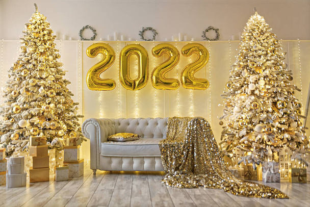 Christmas and New Year decorated interior room with presents and New year tree with 2022 foil air balloons - Φωτογραφία, εικόνα