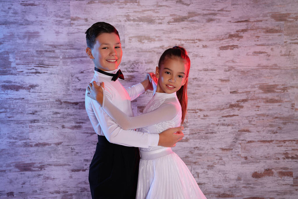 Beautifully dressed couple of kids dancing together in studio - Foto, immagini