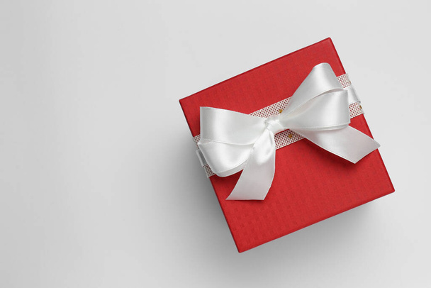 Gift box with bow on white background, top view - Фото, зображення