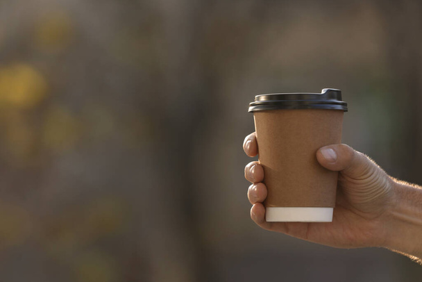 Man with takeaway coffee cup outdoors, closeup. Space for text - Foto, Imagem