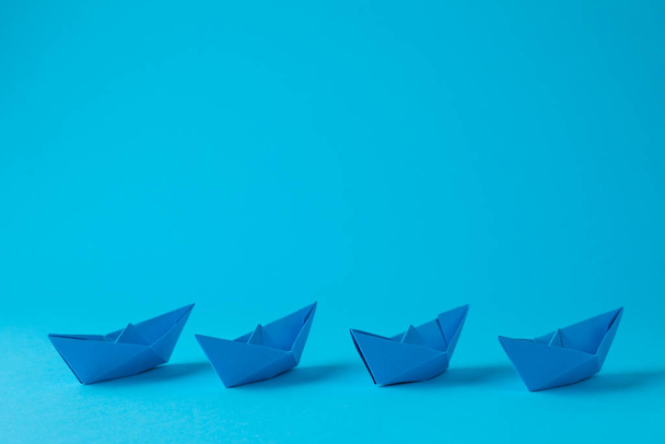 Handmade paper boats on light blue background. Space for text - Foto, Imagen