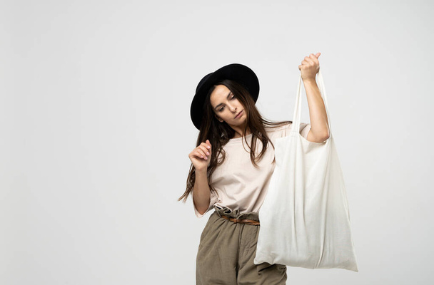 Zero waste concept with copy space. Woman holding cotton shopper with vegetables, products. Eco friendly mesh shopper. Zero waste, plastic free concept. - 写真・画像