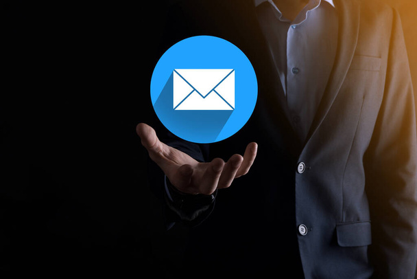 Businessman hand holding letter icon,email icons.Contact us by newsletter email and protect your personal information from spam mail.Customer service call center contact us.Email marketing newsletter - Foto, Imagen