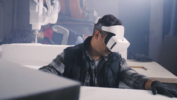 Craftsman in VR goggles working with plastic block - Фото, зображення