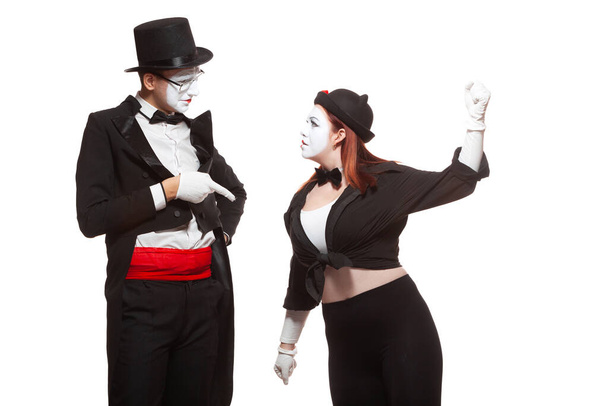 Portrait of two mime artists performing, isolated on white background. Woman raised her fist at the man. Symbol of fight, quarrel, family problems, domestic violence - Photo, image