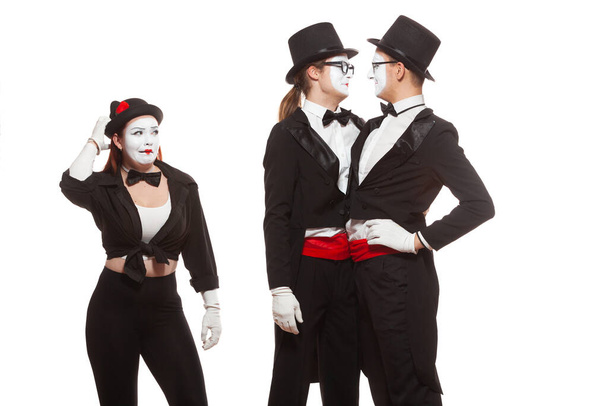Portrait of three mime artists performing, isolated on white background. Two men embrace, and the girl is perplexed. Symbol of tolerance, same-sex marriage, the LGBT community - Photo, image
