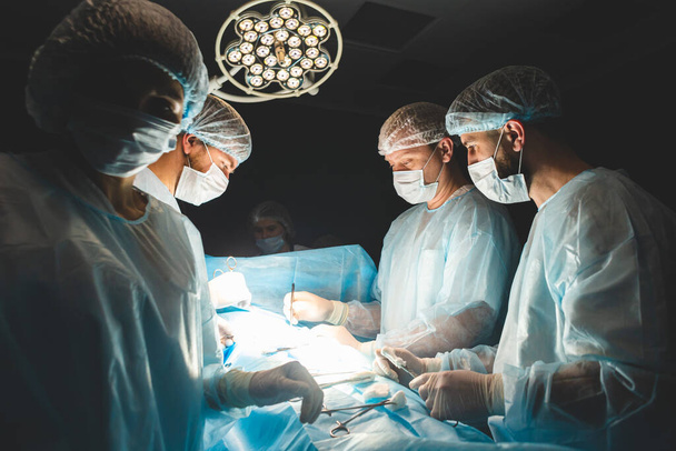 The senior surgeon in the operating room, where the patient is waiting for him, and he begins the operation. Real Modern Hospital with Authentic Equipment. - Photo, image