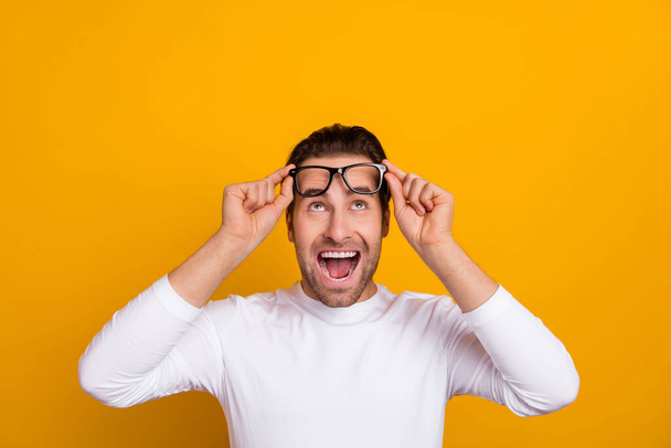 Photo of hooray brunet guy try eyewear look empty space wear white shirt isolated on bright yellow color background - Fotó, kép
