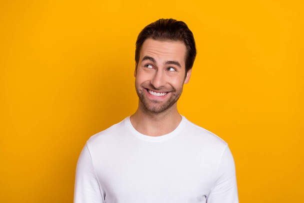Portrait of satisfied candid person toothy smile look interested empty space isolated on yellow color background - Foto, immagini