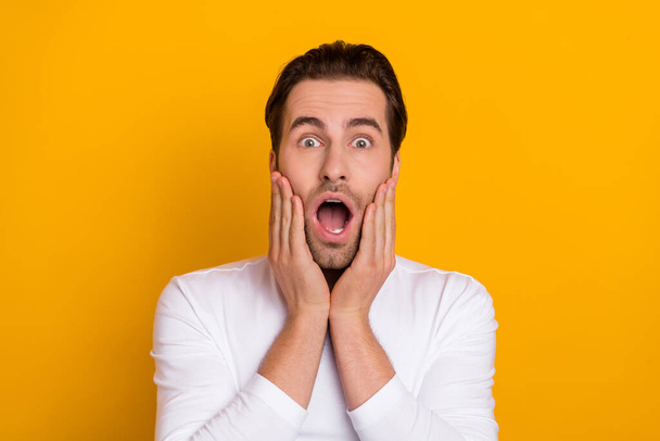 Photo of millennial impressed brunet guy open mouth wear white shirt isolated on bright yellow color background - Foto, immagini