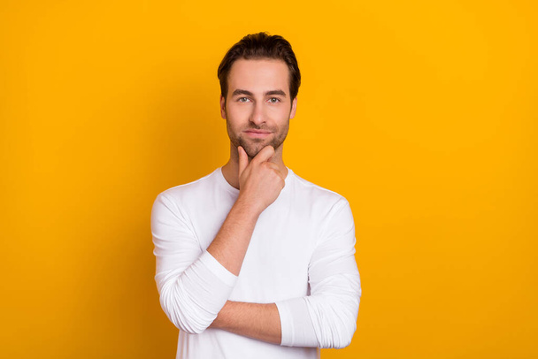 Photo of calm confident minded person arm touch chin look camera isolated on yellow color background - Foto, immagini