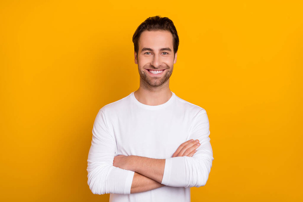 Portrait of satisfied man folded hands toothy beaming smile look camera isolated on yellow color background - Valokuva, kuva