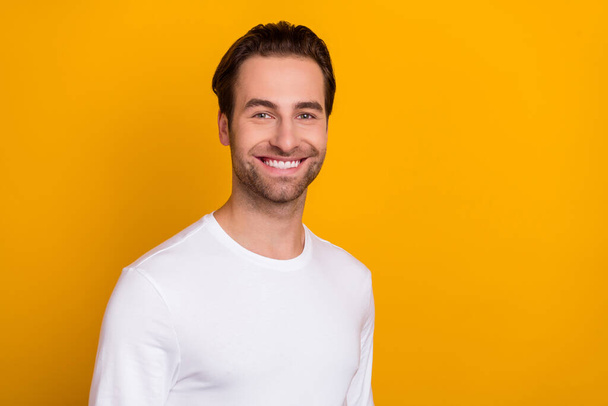 Photo of young cute brunet guy wear white shirt isolated on vivid yellow color background - Foto, Imagem