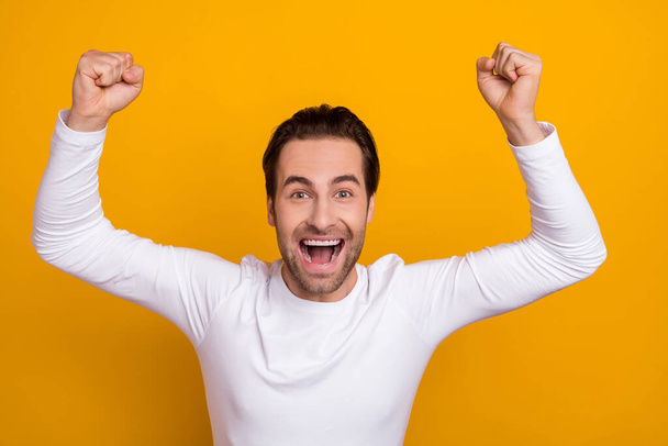 Photo of overjoyed delighted guy raise fists lucky scream hooray yes isolated on yellow color background - Foto, Imagem